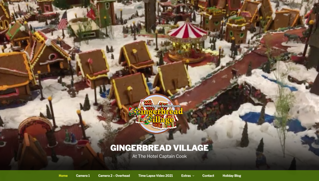 Captain Cook Christmas screen capture of their website including their logo and a gingerbread village in the background.